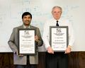 Photo is taken in year 2015, shows Dr. Ulrich L. Rohde and Dr. Ajay K. Poddar received the Award from IEEE IFCS In year 2015: from left-Dr. Ajay Poddar holding Plaque for IEEE W. G. Cady Award and Dr. Ulrich L. Rohde is holding the Plaque I. I. Rabi Award. Dr. Rohde has received the award “For intellectual leadership, selection and measurement of resonator structures for implementation in high performance frequency sources, essential to the determination of atomic resonance” https://ieee-uffc.org/awards/frequency-control-awards/rabi-award/ Dr. Poddar received the award for “For the analysis, design, and development of a host of frequency control products exhibiting state-of-the-art performance, including the development of extremely low noise crystal oscillator circuitry” https://ieee-uffc.org/awards/frequency-control-awards/cady-award/