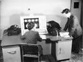 The Ferranti Mark I computer In 1951. John Bennett, who had a desk in the Tin Hut, is on the right. The lady seated at the console is believed to be Joan Hart, a secretary in Manchester University’s Computing Machine Laboratory. Permission from Fujitsu Services Limited, with captioning help from the Ferranti Archive at the Science & Industry Museum, Manchester and the School of Computer Science, University of Manchester.